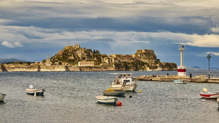 Framed Print : View of an island with fortress and small boats in the water under cloudy sky
