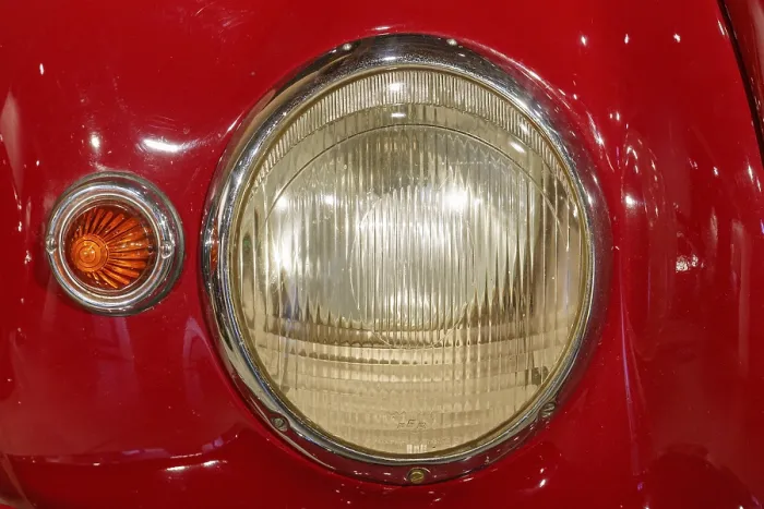 Framed Print : Front view of a red classic car with detailed headlights and chrome-coloured accents