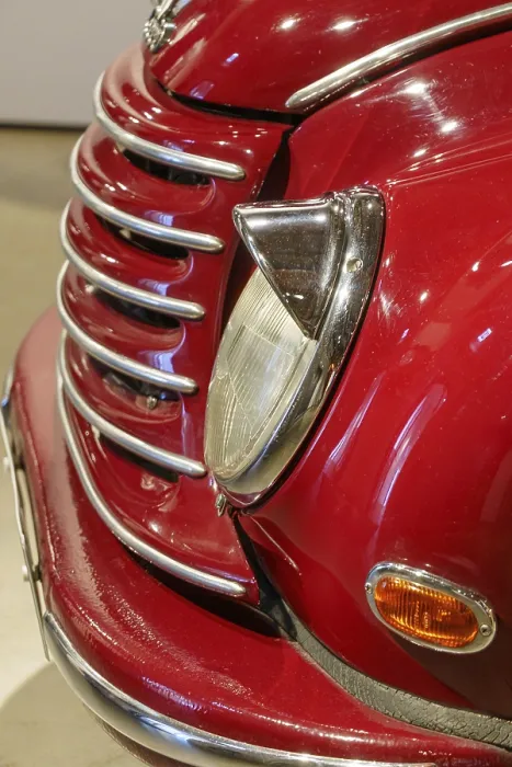 Framed Print : Front view of a red classic car with shiny chrome details and headlights