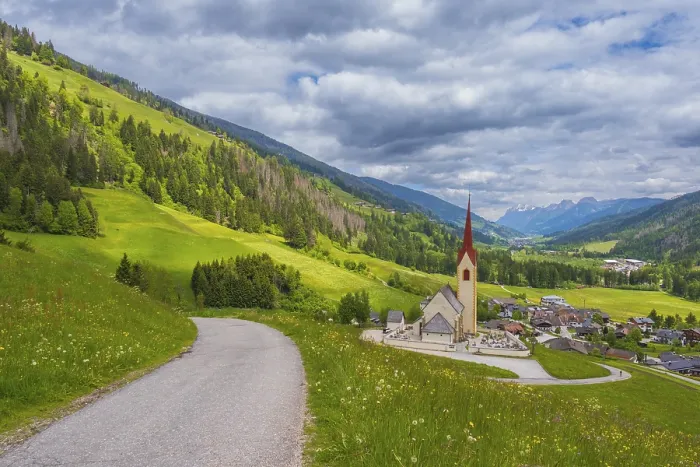 Framed Print : View along a road to the church of Winnebach with the valley behind it