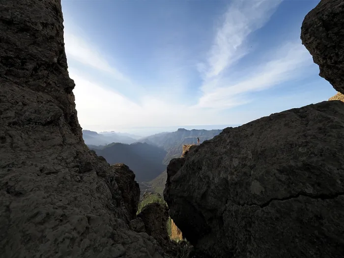 Framed Print : View through rocks of a vast mountain landscape under clear sky