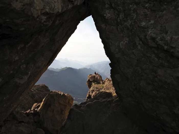 Framed Print : View through a rocky frame of a distant mountain landscape