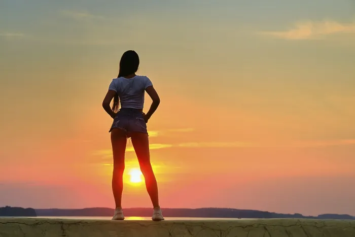 Framed Print : Back view of a silhouette of young woman standing on a pier at the sunset time Framed Print : Back view of a silhouette of young woman standing on a pier at the sunset time