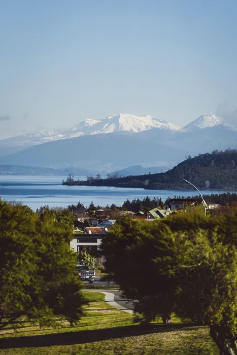 Framed Print : View of snow-capped mountains and a lake with a village in the foreground under a clear sky