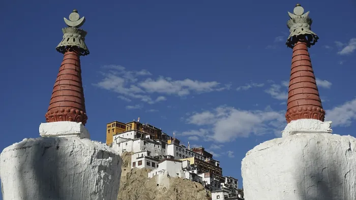 Framed Print : View through two stupas towards Thiksey monastery on a hill under blue sky