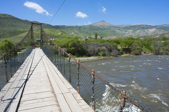 Framed Print : View of a swinging suspension bridge spanning a river Framed Print : View of a swinging suspension bridge spanning a river