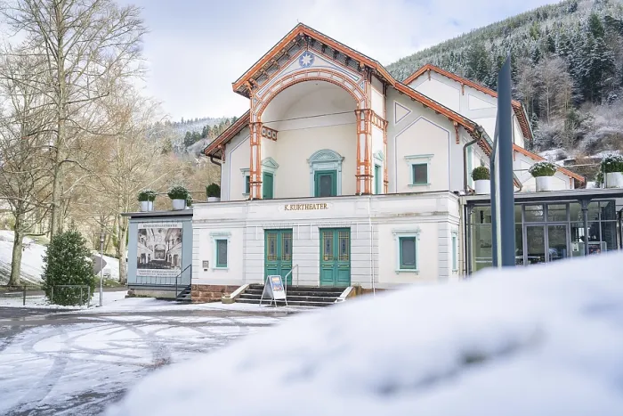 Framed Print : Front view of a theatre in the snow with wooded mountains in the background