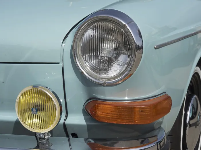 Framed Print : Front view of a turquoise vintage car with additional yellow headlights and chrome details