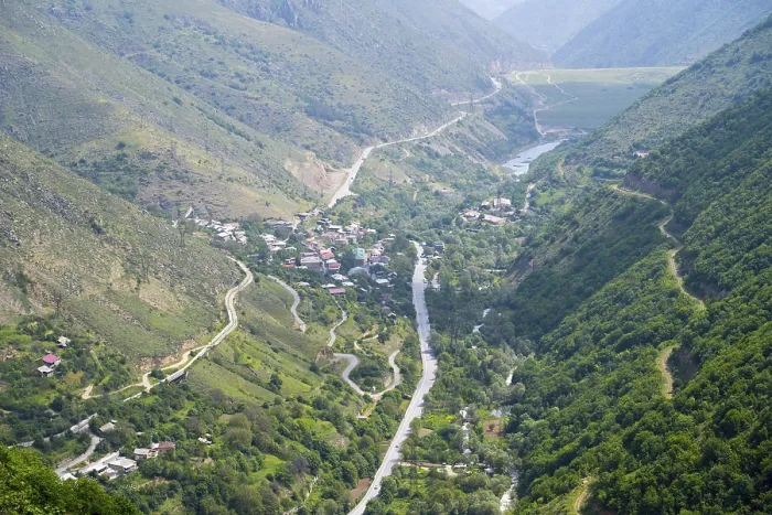 Framed Print : View of a village in the valley surrounded by green hills and a river Framed Print : View of a village in the valley surrounded by green hills and a river