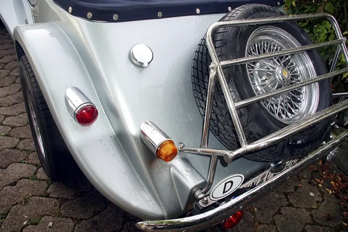 Framed Print : Back view of a vintage car with spare tires and chromed elements on cobblestones