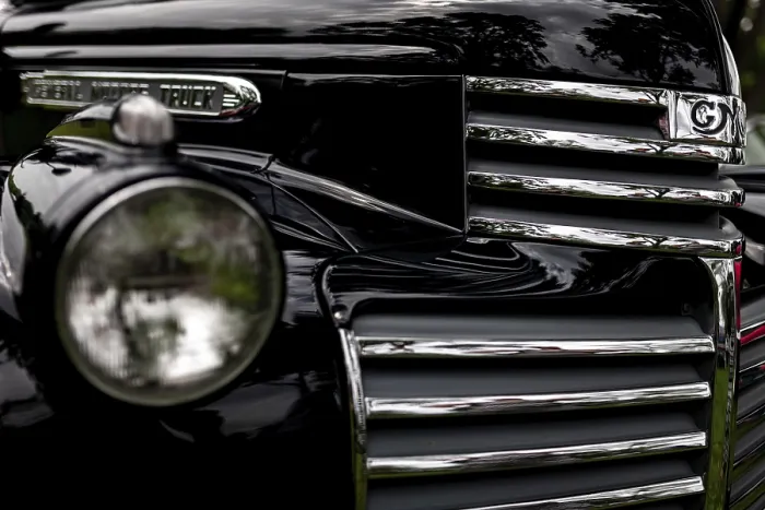 Framed Print : Front view of a vintage truck featuring a chrome grille and round headlight on a black finish in St