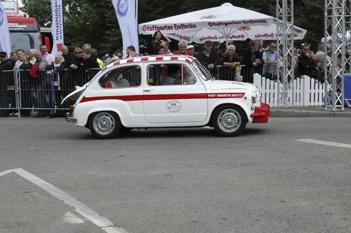 Framed Print : Side view of a white small vintage car at a race