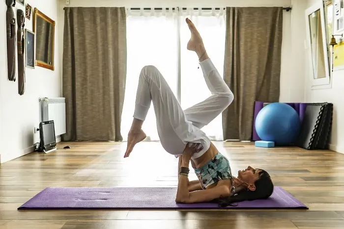 Framed Print : Side view of a woman practicing yoga on a mat Framed Print : Side view of a woman practicing yoga on a mat
