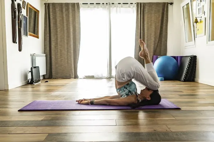 Framed Print : Side view of a woman practicing yoga on a mat
