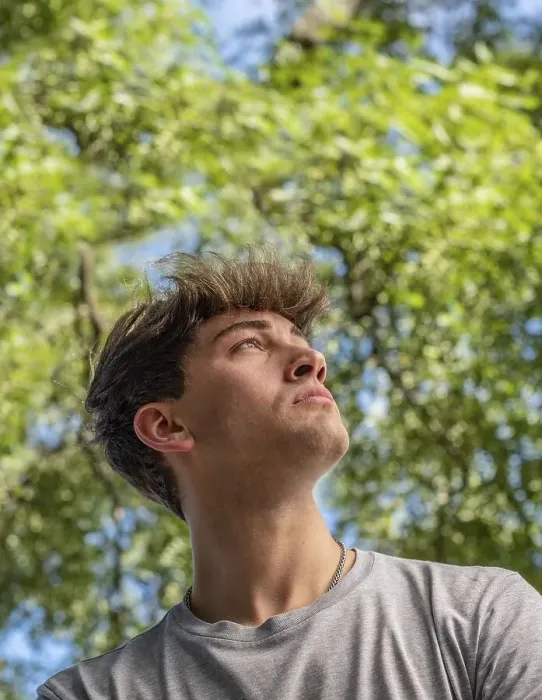 Framed Print : Side view of a young man who is looking up over nature background