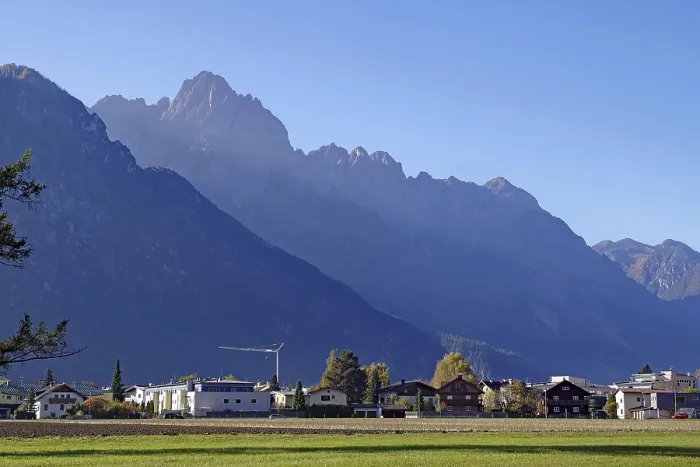 Framed Print : Village at the foot of rugged mountains