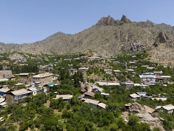 Framed Print : Village surrounded by lush vegetation and high mountains in a sunny landscape