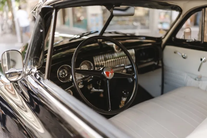 Framed Print : A vintage car with a black steering wheel and a white dashboard