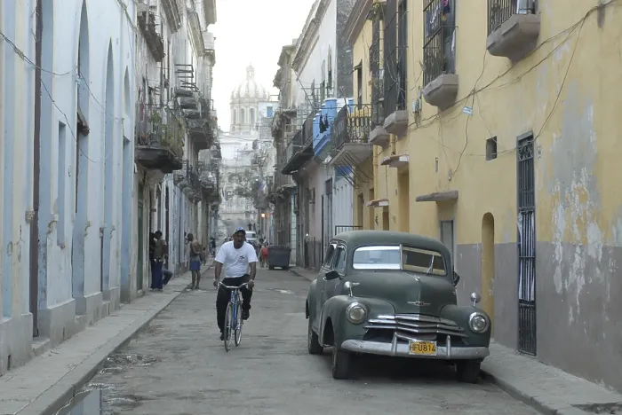 Framed Print : Vintage car and cyclist in an alley in the old part of Havana