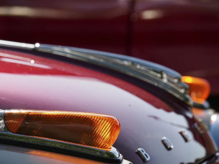 Framed Print : Detail of a vintage car with red paintwork and chrome accents