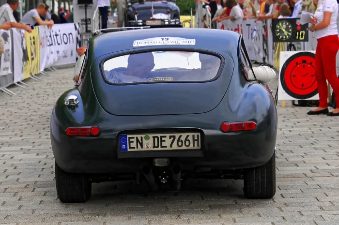 Framed Print : Vintage green jaguar car seen from behind with spectators at an event