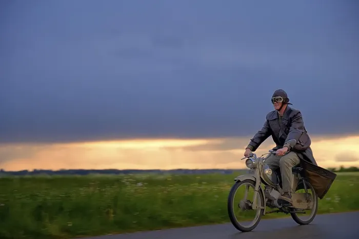 Framed Print : Vintage motorcyclist in front of a dramatic cloudy sky