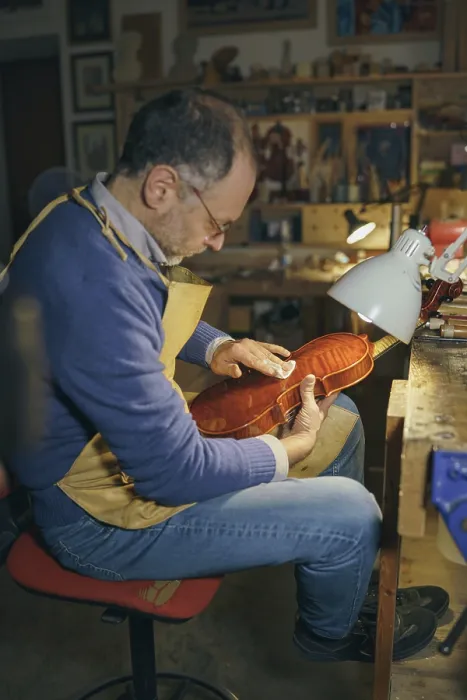 Framed Print : Violin maker carefully crafting a new instrument in his workshop surrounded by various tools showcasing his skills