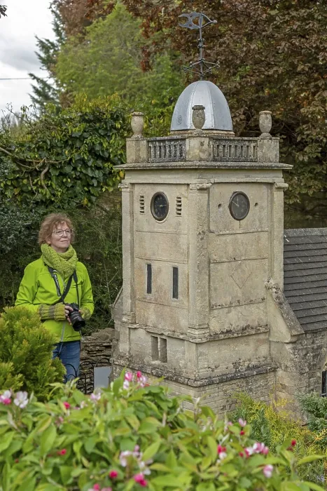 Framed Print : Visitor looking at church tower at miniature village