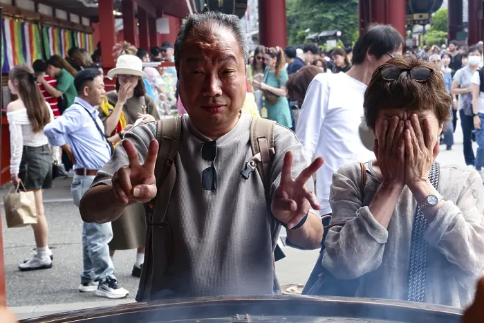 Framed Print : Visitors to Senso-ji Temple pose in front of a large fire bowl Framed Print : Visitors to Senso-ji Temple pose in front of a large fire bowl
