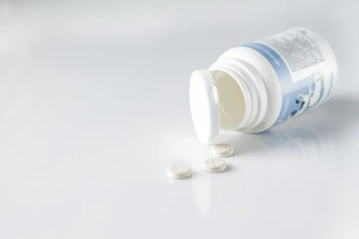 Framed Print : Vitamins for cats and dogs falling out of a white plastic jar