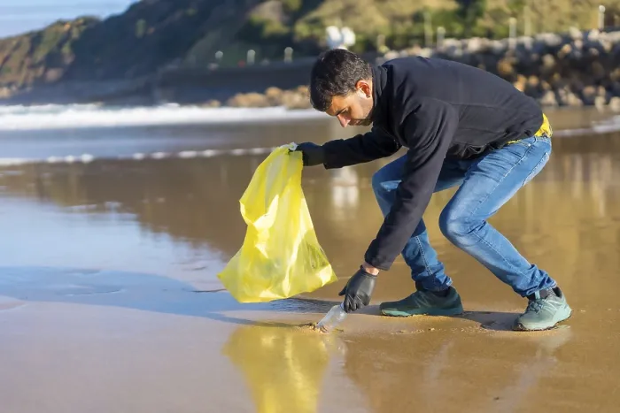 Framed Print : Volunteer man collecting garbage or plastic on the beach