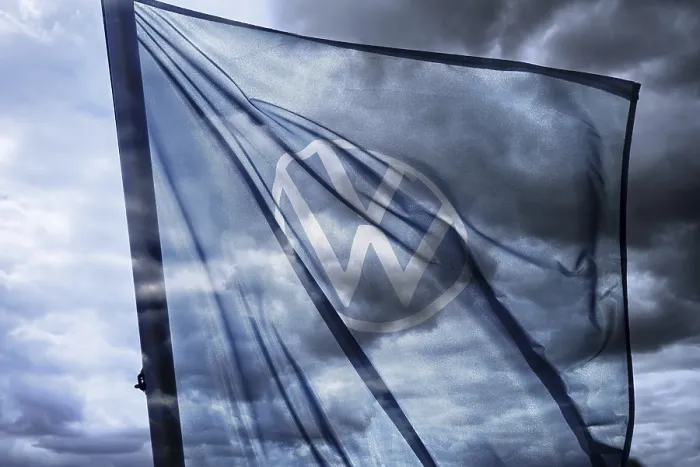 Framed Print : VW sign on the flag of a car dealer in front of a dark sky