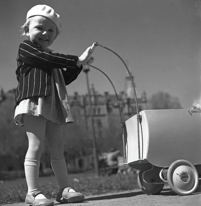 Framed Print : For a walk in the 1940s. A child is playing in the park pushing a doll pram Framed Print : For a walk in the 1940s. A child is playing in the park pushing a doll pram