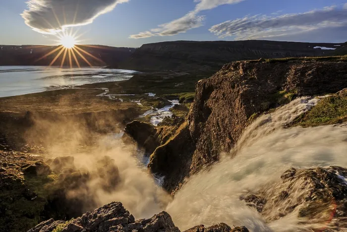 Framed Print : Waterfall backlit by midnight sun in front of mountains and coast