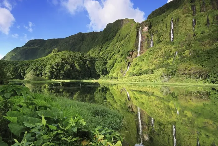 Framed Print : Waterfalls on the forested slope of a volcano reflected in a lake