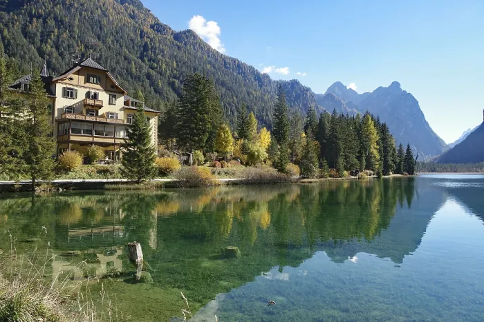 Framed Print : Waterfront villa on a clear mountain lake reflected against rugged peaks