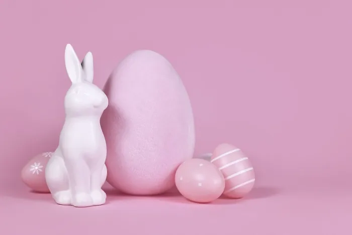 Framed Print : White bunny sculpture with easter eggs on pink background with copy space
