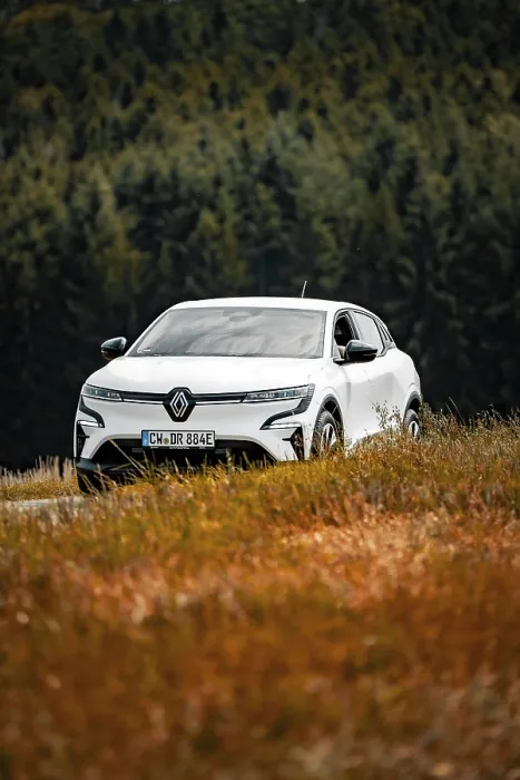 Framed Print : A white car drives through a beautiful meadow landscape surrounded by trees
