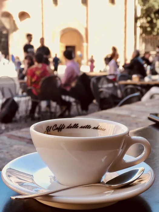 Framed Print : White coffee cup on a table in a busy street cafe