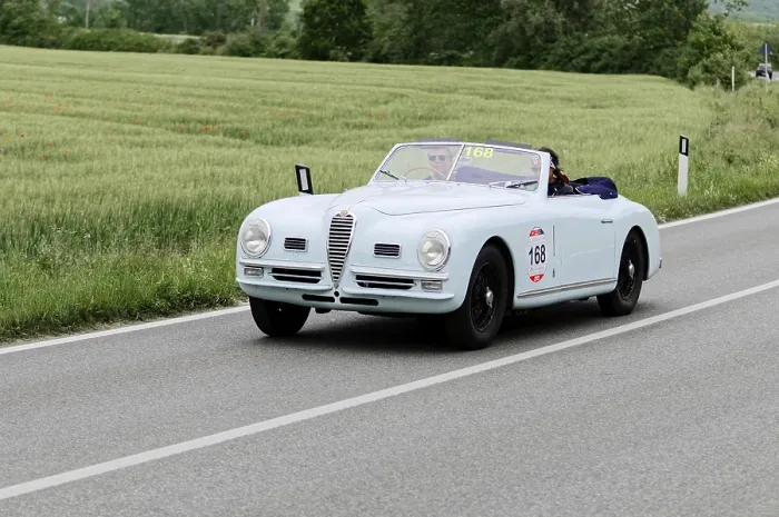 Framed Print : A white convertible classic car drives on a country road