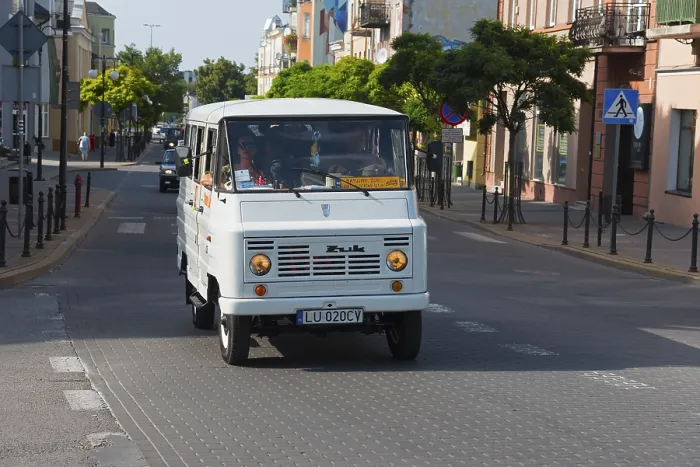 Framed Print : White minibus in an urban environment on a busy street