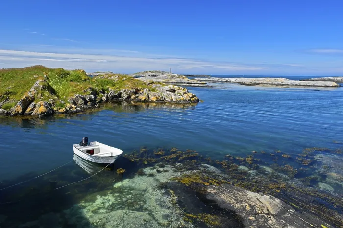 Framed Print : White motorboat anchored in a bay in the rocky coastal scenery at Bud