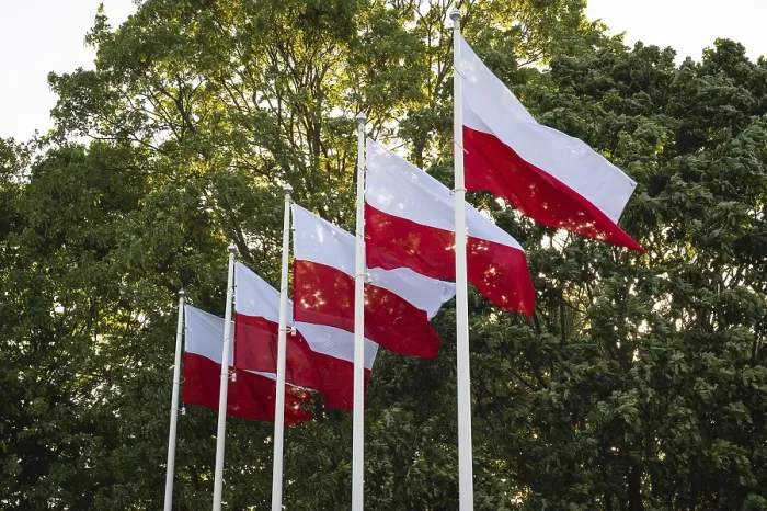 Framed Print : Five white and red flags flying on masts against the background of green trees Framed Print : Five white and red flags flying on masts against the background of green trees