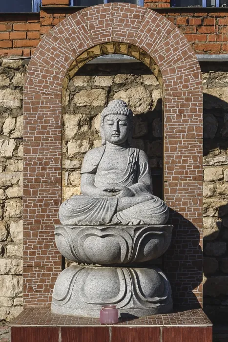 Framed Print : White stone statue of a Buddha on masonry background Framed Print : White stone statue of a Buddha on masonry background