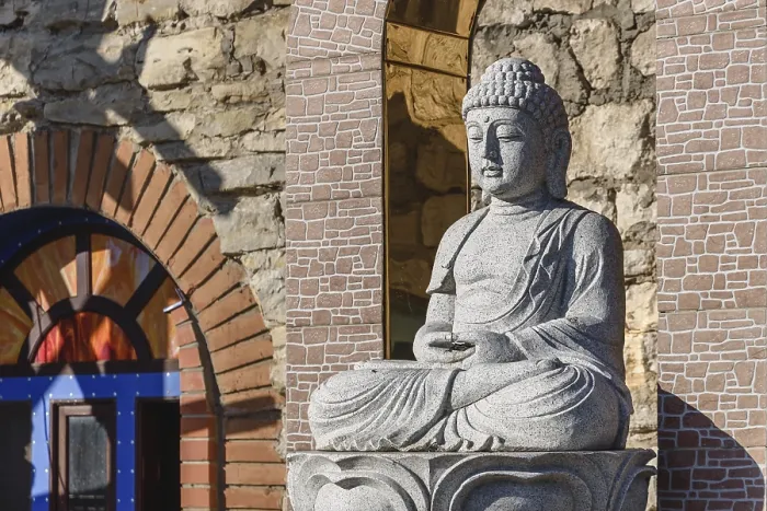 Framed Print : White stone statue of a Buddha on masonry background