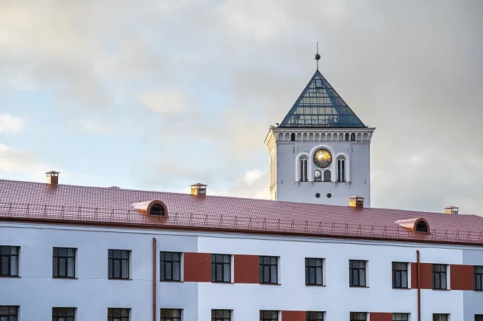 Framed Print : A white tower with a clock and a fragment of a modern building on the background of the sunset sky Framed Print : A white tower with a clock and a fragment of a modern building on the background of the sunset sky