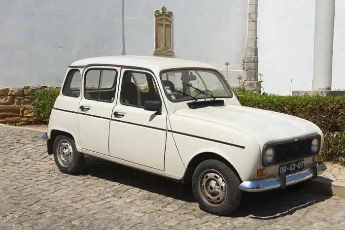 Framed Print : White vintage car on cobblestones in front of a historic building