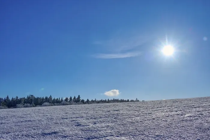 Framed Print : Wide expanse of snow under a clear blue sky with bright sun