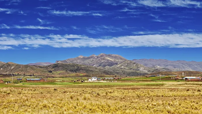 Framed Print : Wide fields in front of a mountain range under a cloudy sky