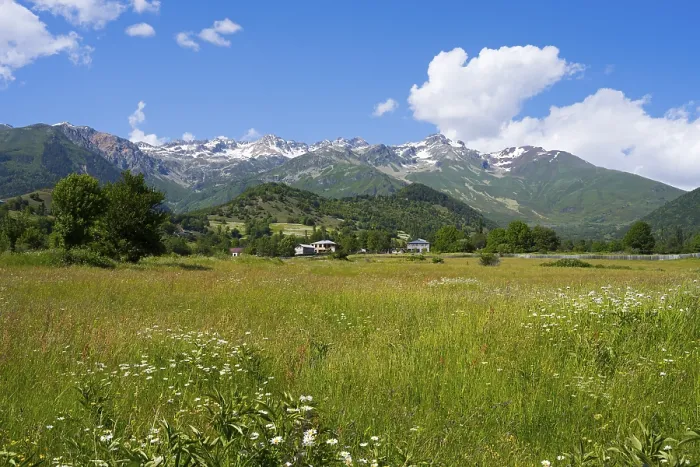 Framed Print : Wide meadow landscape with views of mountains and cloudy blue sky